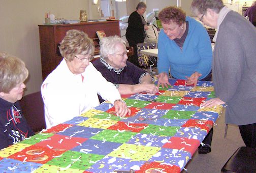 Reid's Corners WI ladies work together tying quilts